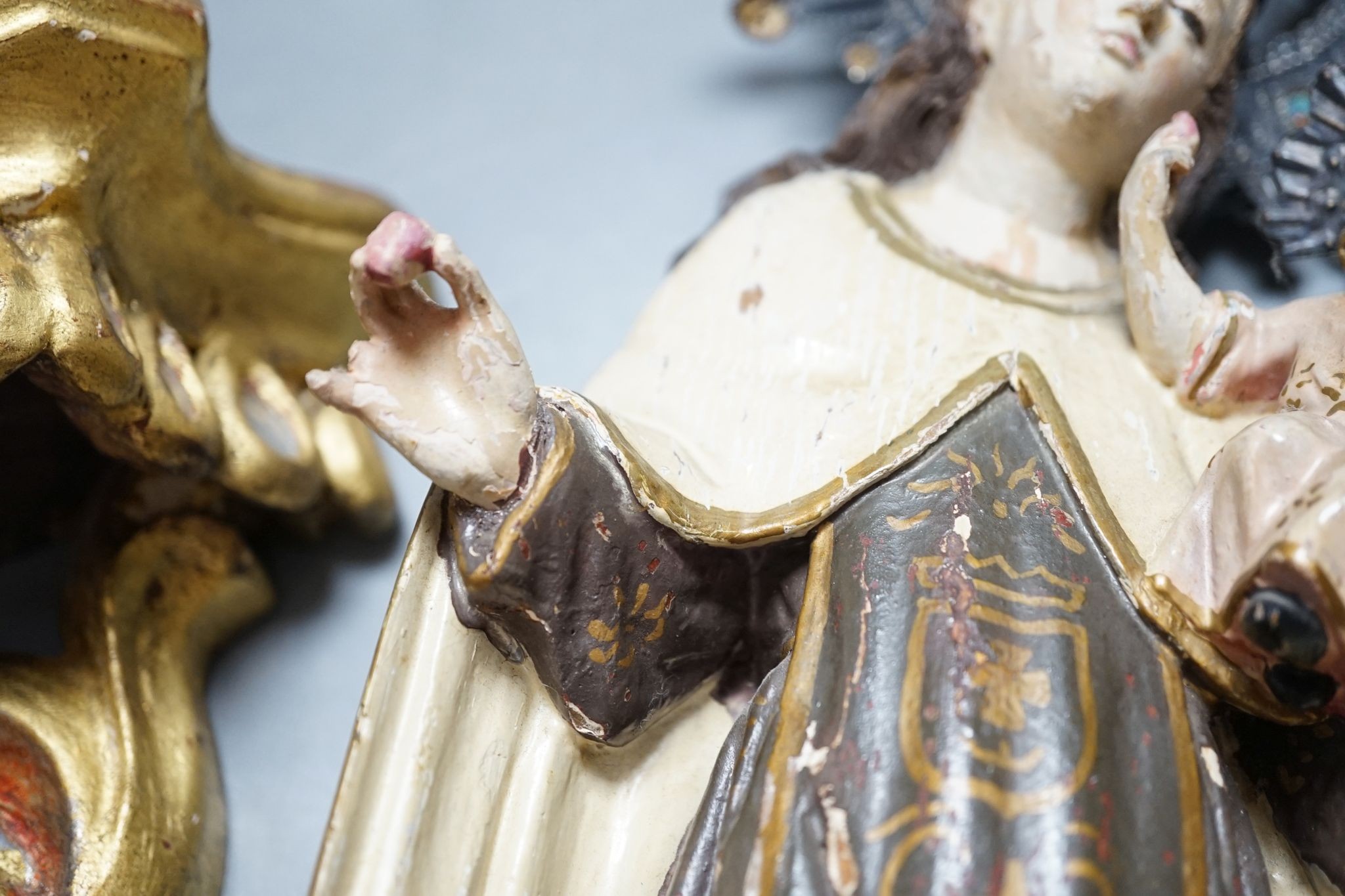 An ornate South American Madonna and child with a metal crown and halo, standing on a carved bracket, 39cm